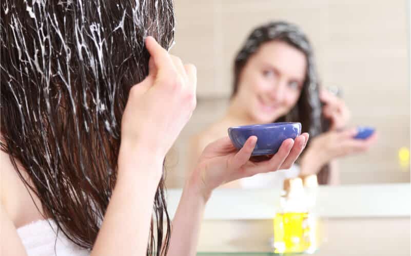 woman putting mask on hair-hair masks for cold weather
